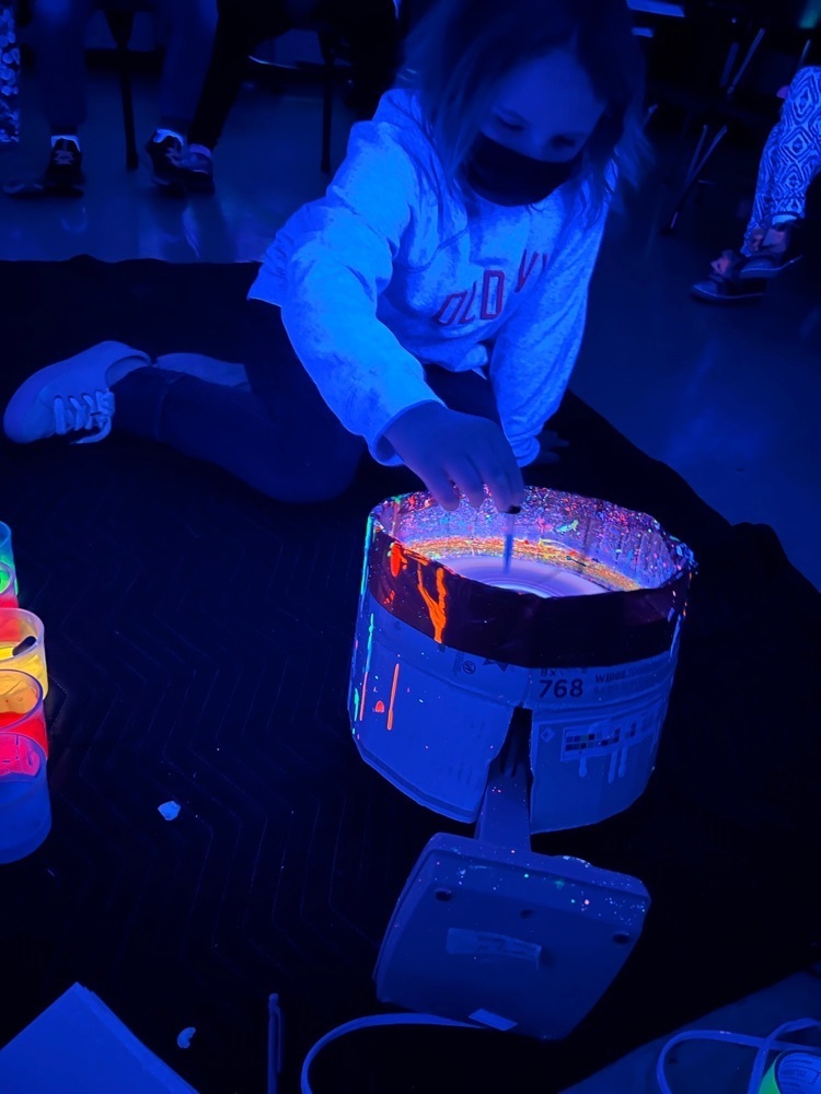 Students in the dark participating in glow and paint.